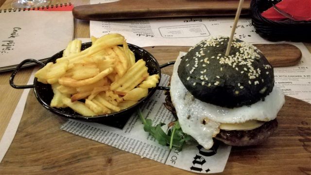 Schwarzes Brötchen mit Spiegelei, Risenpatty und Garnelen